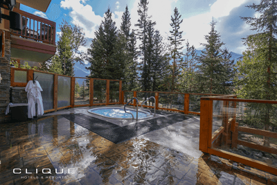 Outdoor hot tub area at Falcon Crest Lodge features a bubbling hot tub surrounded mountain and evergreen tree views