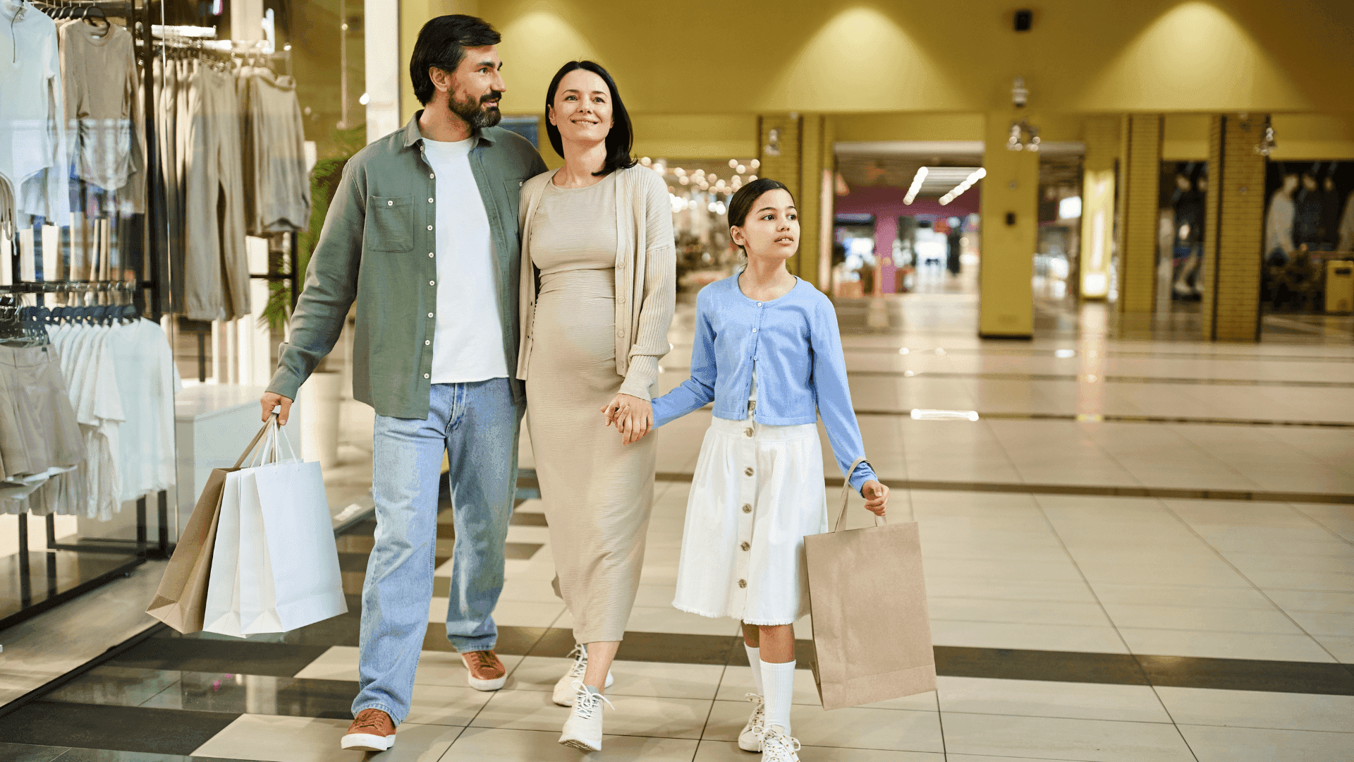 Happy family with shopping bags walking through Galerías Celaya shopping mall near Real Inn Celaya