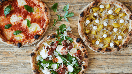 Three gourmet pizzas with toppings like prosciutto and mozzarella at Pizzaperta Manfredi in Novotel Sydney