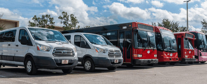 White shuttle bus by the entry of Galleria Palms Hotel, a budget hotel near Orlando theme parks with a shuttle