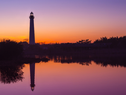 Purple and orange sky silhouettes the Cape May lighthouse near our Cape May hotel