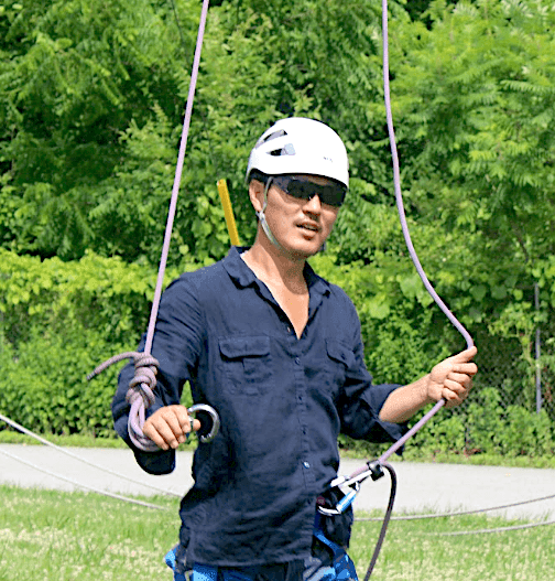 Alex Kim with ziplining equipment at Honor's Haven Retreat