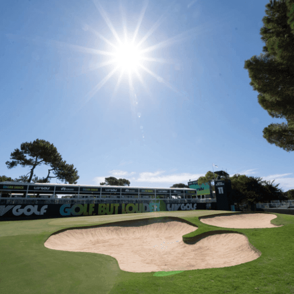LIV Golf event with sun and sand bunkers on the green course.
