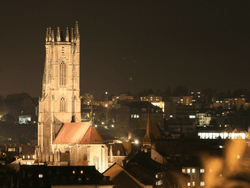 Sunrise over a historic cityscape featuring Fribourg Cathedral near Hotel des Innovations