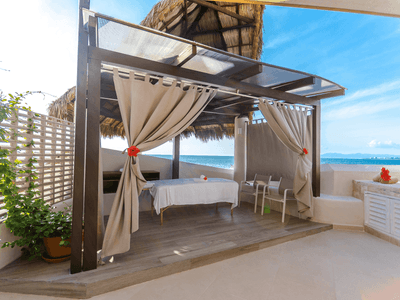 Cabana with curtains, massage beds, and ocean view in Shakti Spa at Buenaventura Grand Hotel and Spa