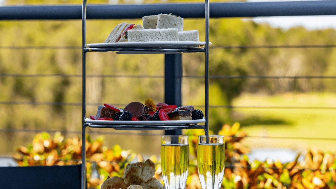 Three-tiered High Tea stand with pastries, sandwiches, and champagne flutes at Mercure Kooindah Waters