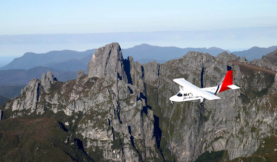 A plane flying through the mountains near Gordon River Cruise