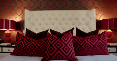 Close-up on red & black pillows on a bed at Stein Eriksen Residences
