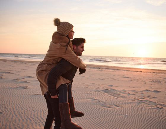 Couple in winter clothes on the beach enjoying our Avalon hotel deals
