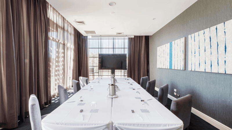 Boardroom Two with a long table, chairs, and abstract wall art at Mercure Kooindah Waters