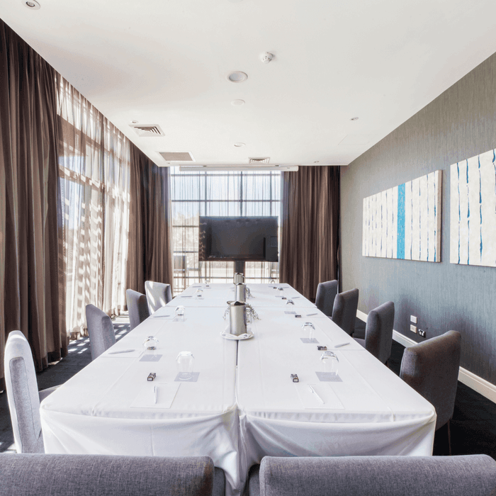 Boardroom Two with a long table, chairs, and abstract wall art at Mercure Kooindah Waters