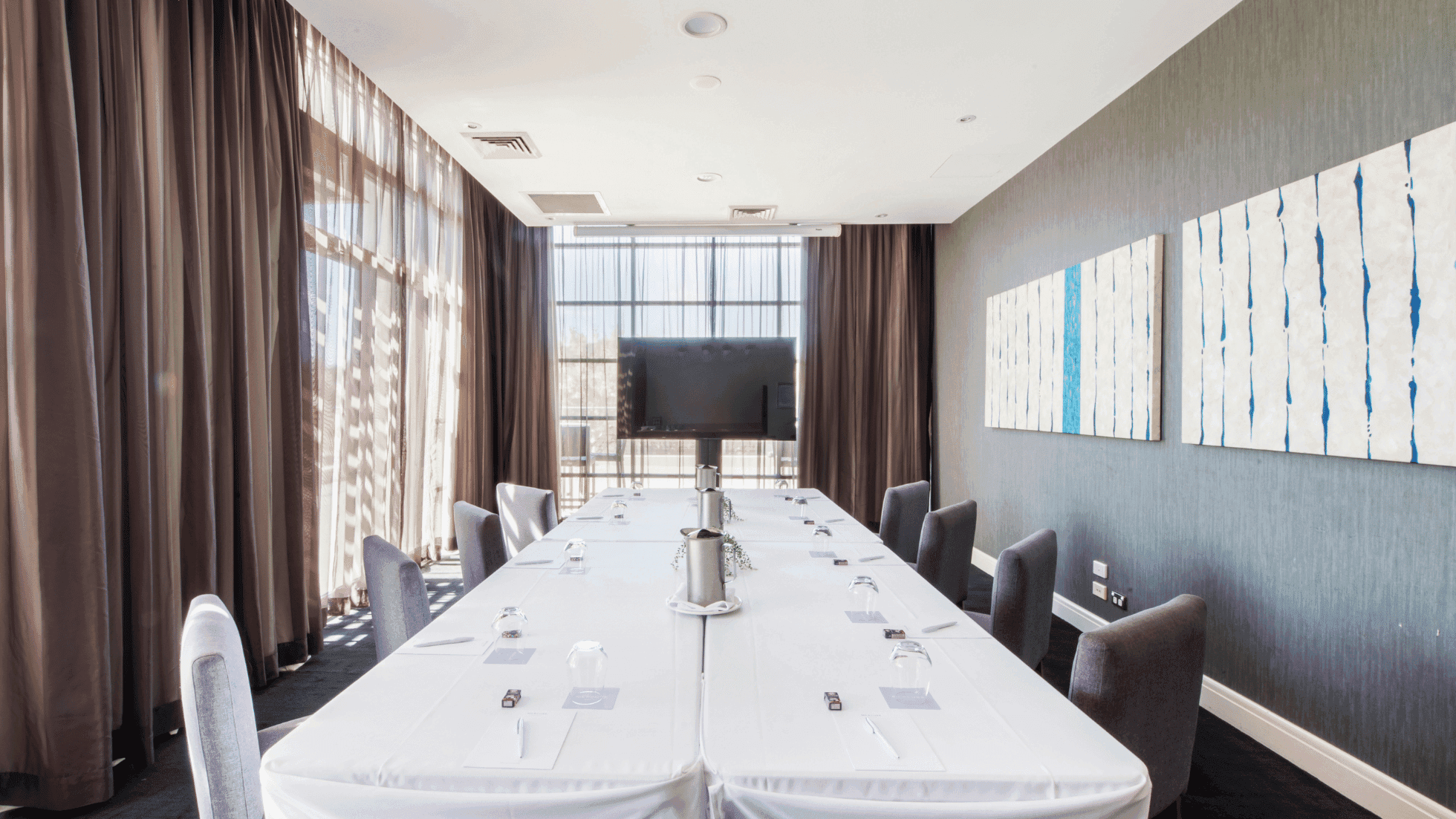Boardroom Two with a long table, chairs, and abstract wall art at Mercure Kooindah Waters