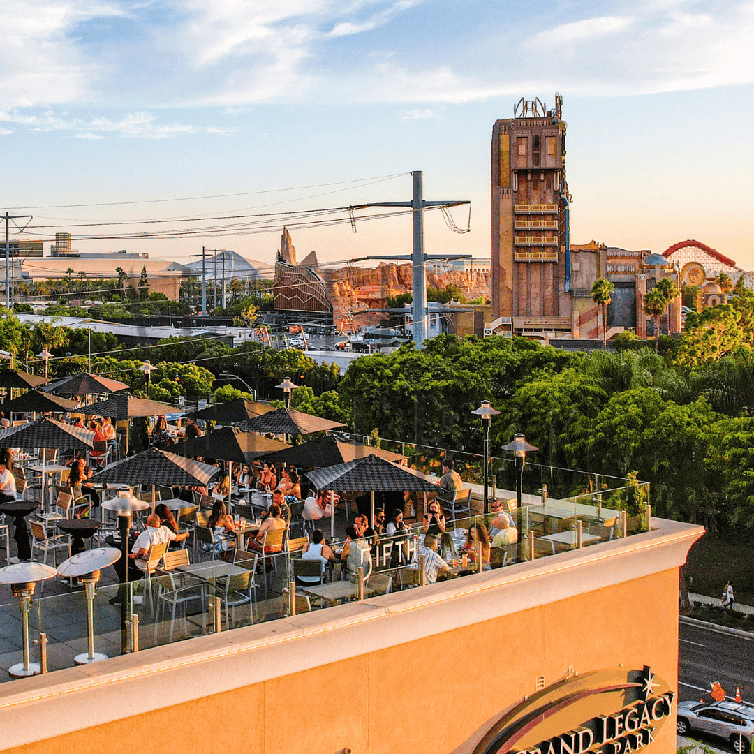 A rooftop bar with outdoor seating and a city view