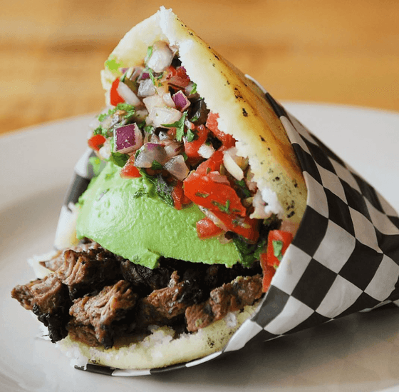 signature stuffed arepa with toppings  from Doggis Arepa Bar in MiMo District, Miami