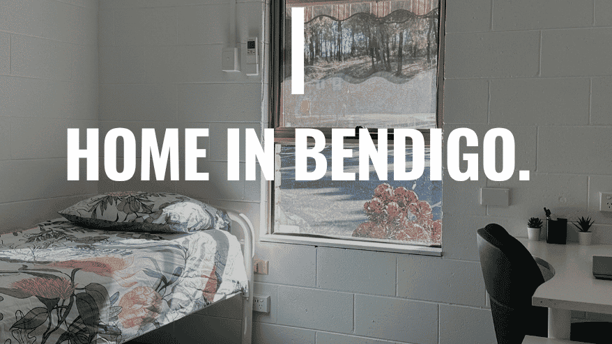 Simple student bedroom with single bed, desk, chair, and window overlooking campus at La Trobe University Orde House