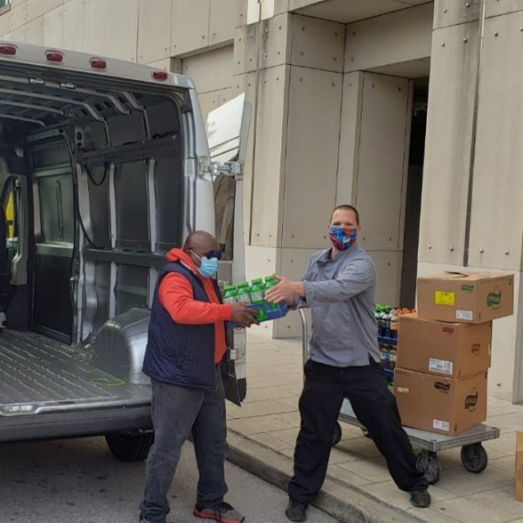 Two men unloading goods from a van at Kellogg Conference Center