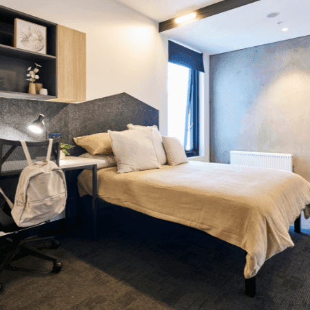Modern room with desk, chair, and bed at UniLodge Lincoln House.