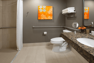 Bathroom featuring grab bars, a shower, and a granite vanity in King Balcony ADA Accessible at Paramount Hotel Portland