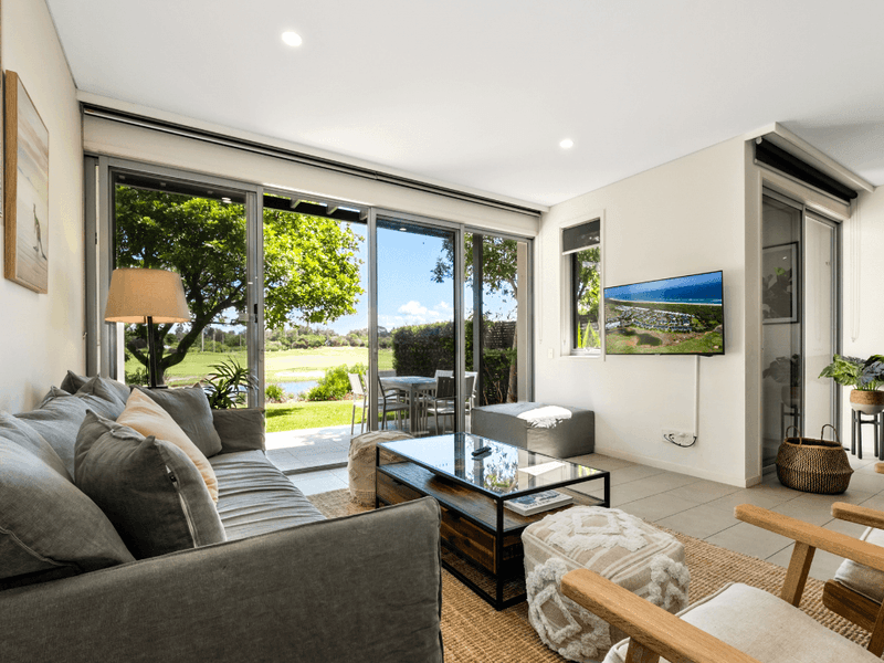 Living area arranged with a cozy sofa and a TV at Pullman Magenta Shores