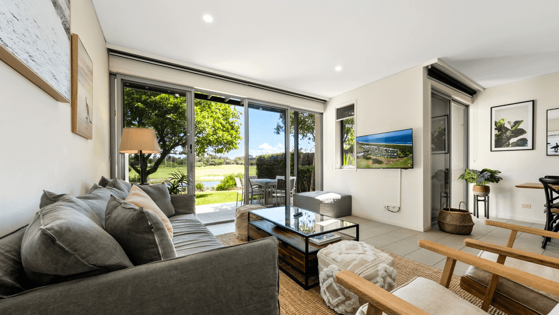 Living area arranged with a cozy sofa and a TV at Pullman Magenta Shores