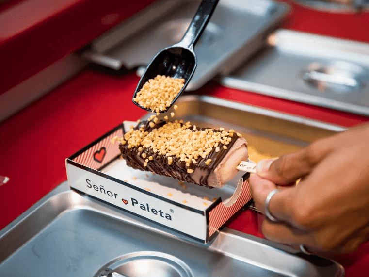 Paleta de chocolate cubierta con cacahuates siendo preparada en Señor Paleta