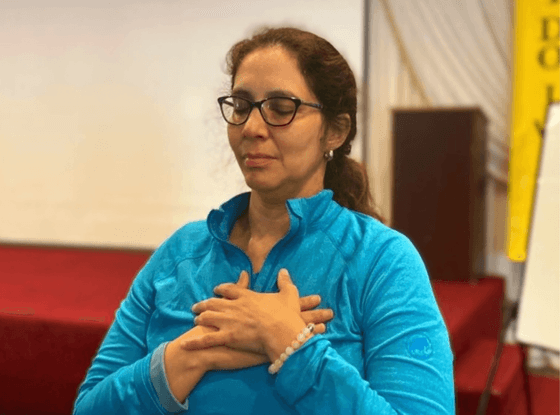 A lady meditating with her hands on chest at Honor’s Haven Retreat