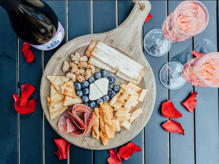 Charcuterie board and a bottle of wine for a Valentines package