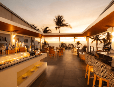 Sky Bar with wicker chairs, bar counter and ocean view at Buenaventura Grand Hotel and Spa