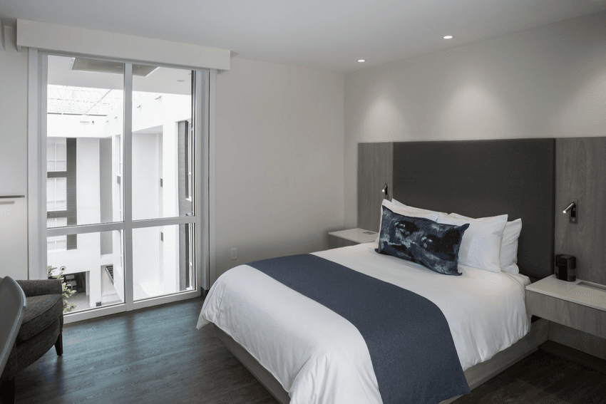 Comfy bed & pillows in Queen Guest Room at Innovation Hotel