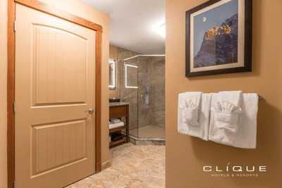 Modern bathroom at Falcon Crest Lodge, featuring a glass-enclosed shower and plush white towels hanging on the wall