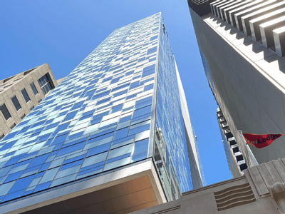 Tall building with reflective windows and a red flag with 