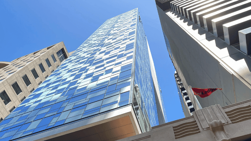 Tall building with reflective windows and a red flag with 