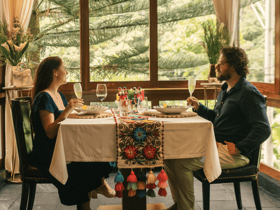 Pareja disfrutando una cena romántica con vistas a la vegetación tropical en Sumaq Machu Picchu Hotel