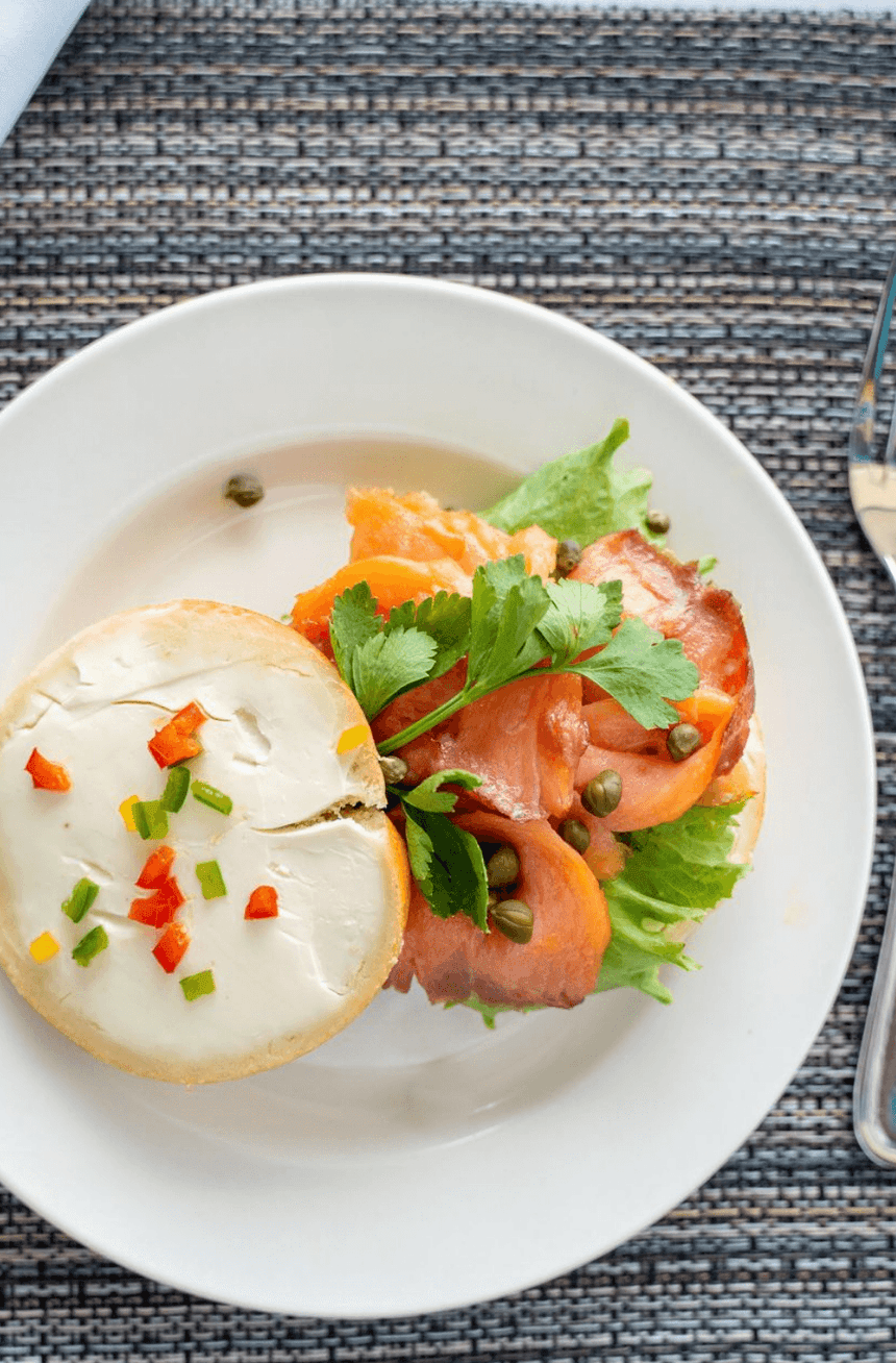 Plate of smoked salmon on lettuce, topped with capers & cilantro, served at Bay Gardens Beach Resort & Spa