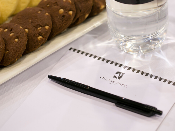 A pen, a book with hotel logo & cookies in Duxton Hotel Perth