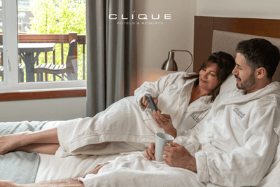 Relaxed couple in robes enjoys their suite at Falcon Crest Lodge with a balcony view