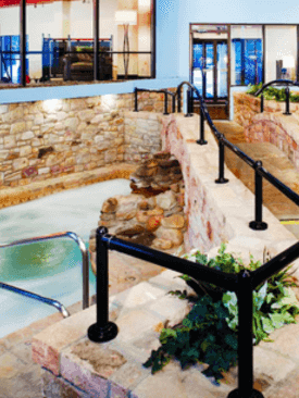 High angle view of the Indoor Hot Tub with a stone wall architecture at Cove Pocono Resorts