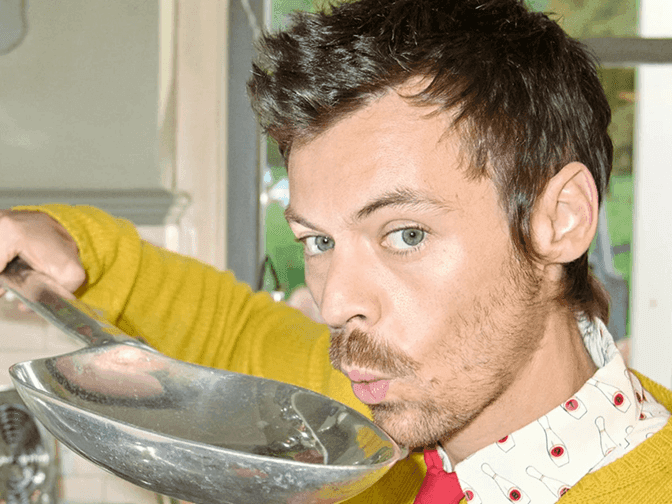 Man in a yellow sweater holding a large spoon at Harry Styles Together, Together Tour 2026.