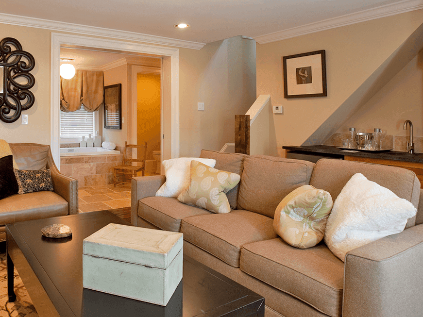 The School House Cottage cozy living room with a beige couch, coffee table in Inn at Willow Grove