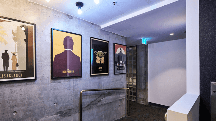 Framed posters of Casablanca, Godfather, Baby Yoda, and Back to the Future on a concrete wall.