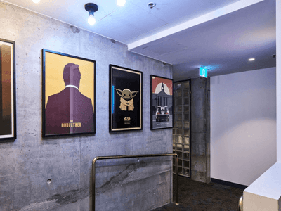 Framed posters of Casablanca, Godfather, Baby Yoda, and Back to the Future on a concrete wall.