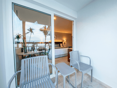 Balcony area with two chairs and table in Deluxe King Bed Ocean View at Buenaventura Grand Hotel and Spa