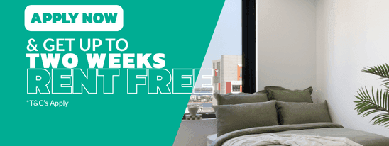 Studio Apartment with green bedding, wooden flooring, and city views at UniLodge Perth Central