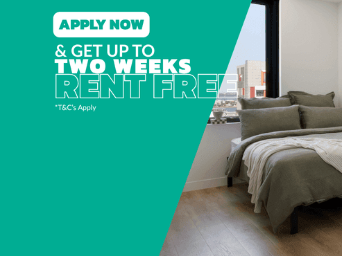 Studio Apartment with green bedding, wooden flooring, and city views at UniLodge Perth Central