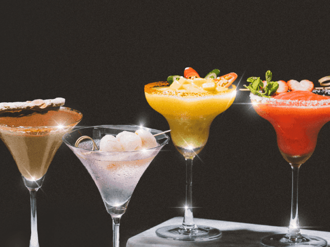 A row of four distinct cocktails, each showcasing unique colors and garnishes, elegantly displayed for visual appeal.