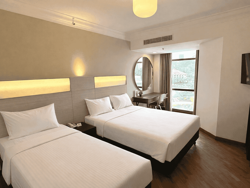 Wall-mounted TV and workspace by the cozy beds in the Superior Queen Triple Room with wooden floors at YWCA Fort Canning