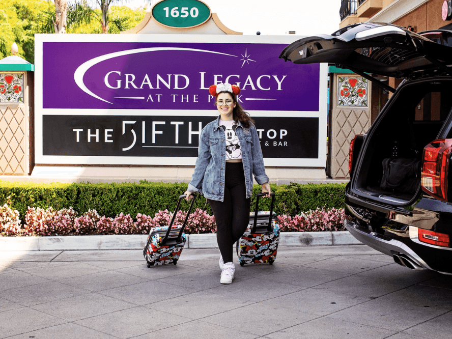 Woman arriving at the Grand Legacy at the Park with Luggage.