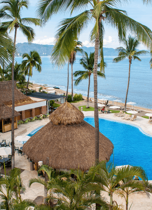High-angle view of the beach & pool area with palm trees at Plaza Pelicanos Club Beach Resort