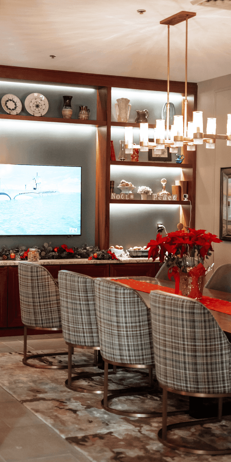 Plaid dining chairs set by a table with a poinsettia centerpiece beneath a gold chandelier at La Tourelle Inn and Spa