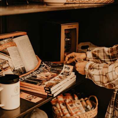 Guest browsing merchandise on a shelf with books and apparel displayed inside the shop at La Tourelle Hotel and Spa